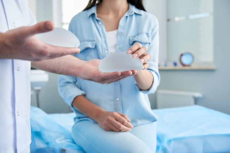 Woman holding breast implants