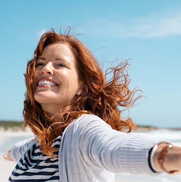 Happy,Mature,Woman,With,Arms,Outstretched,Feeling,The,Breeze,At