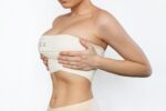 Fit young woman wearing compression garment after breast lift and reduction