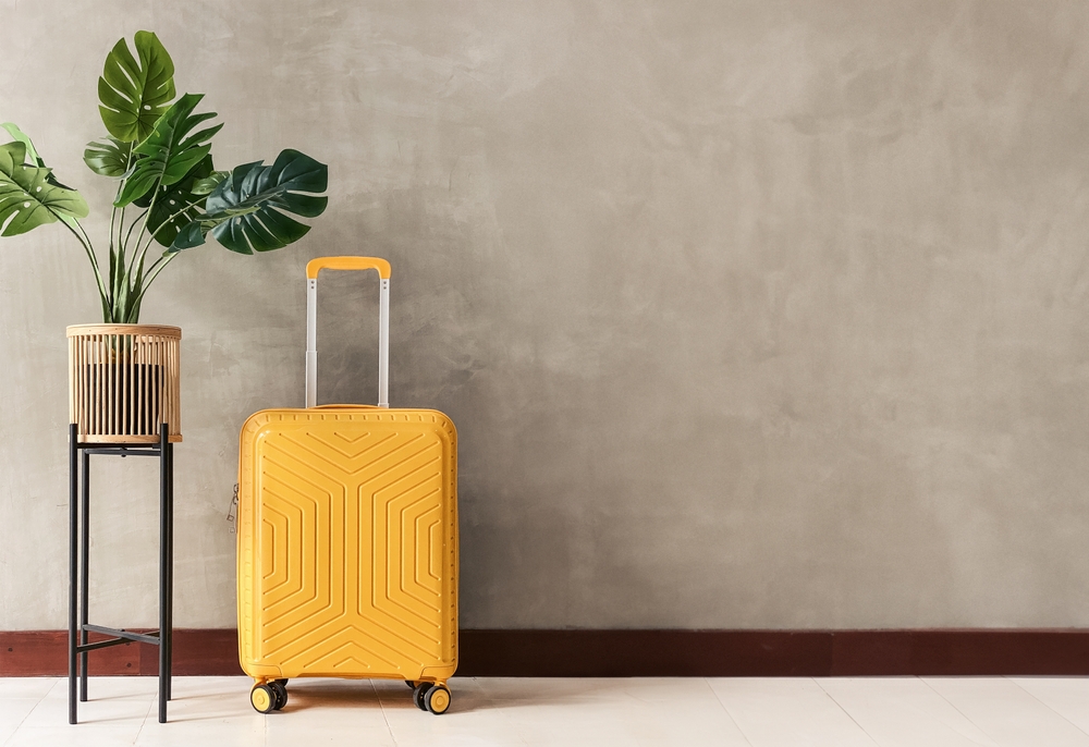 Bright yellow suitcase, packed and ready to travel to Nashville for cosmetic surgery