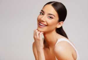 Beautiful woman in her early 30s smiles, delighted with the effects of her collagen banking treatments for skin