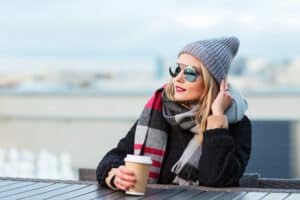 Beautiful woman in winter gear poses outdoors before her plastic surgery appointment